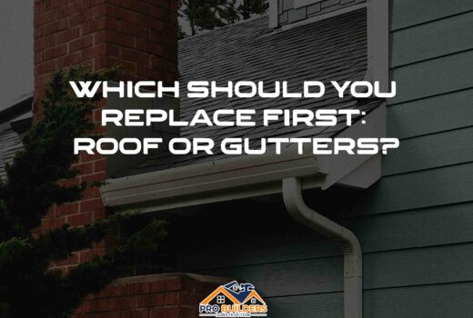 A house with a brick chimney and a gray roof. The gutters are white and there is a downspout visible. The text on the image reads: "WHICH SHOULD YOU REPLACE FIRST: ROOF OR GUTTERS?"