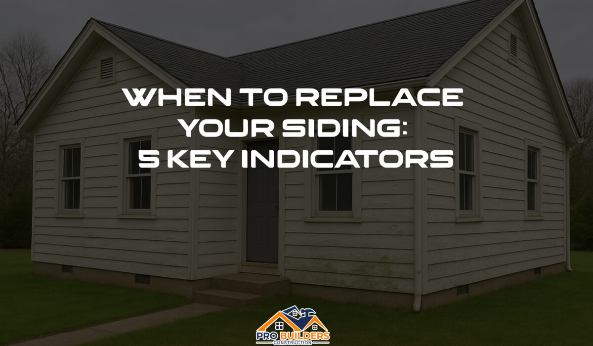White house with aged siding showing signs of wear, discoloration, and mild mold—used to illustrate signs it's time to replace your home’s siding