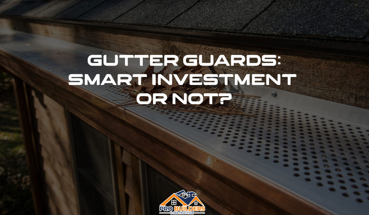 Close-up of a perforated metal gutter guard installed on a residential roof, effectively blocking dry leaves and pine needles from entering the copper gutter system.