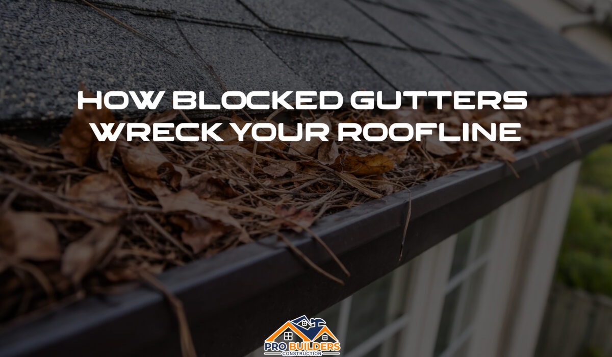 Clogged residential gutter filled with dry leaves, pine needles, and twigs along a shingled roof edge on a suburban home.